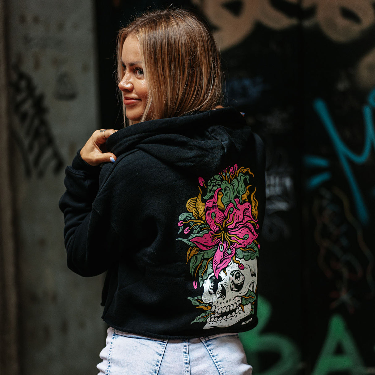 Female model wearing women's crop hoody with 'Eternal Bloom' graphic