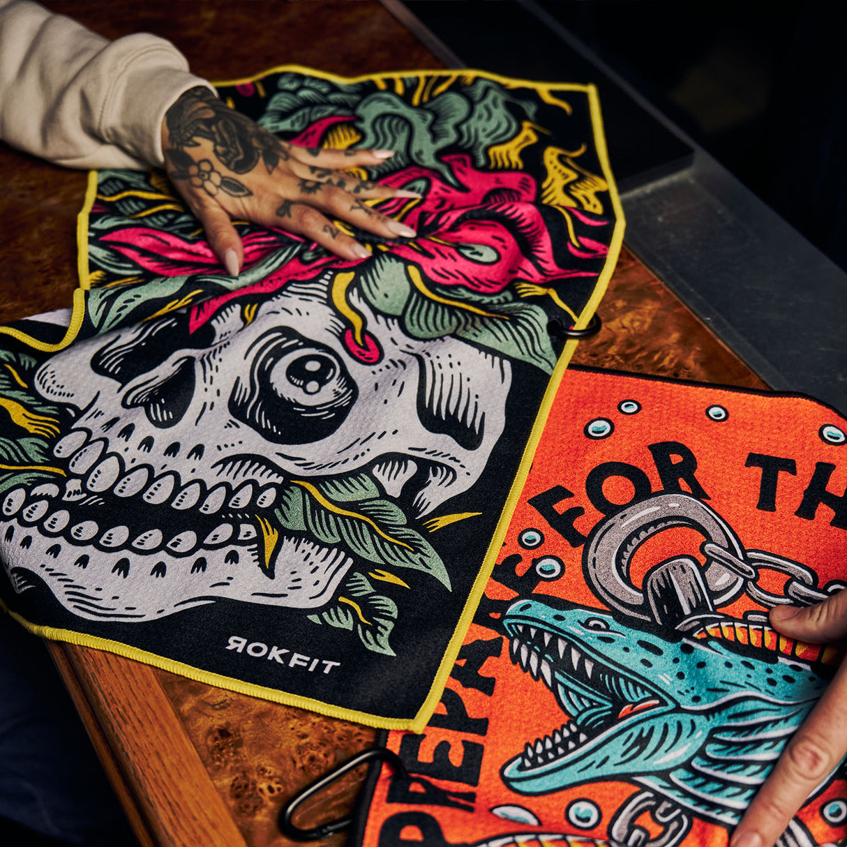 Close up of Utility Towels with 'Eternal Bloom' and 'Prepare For The Unknown' graphic while being used on bar top