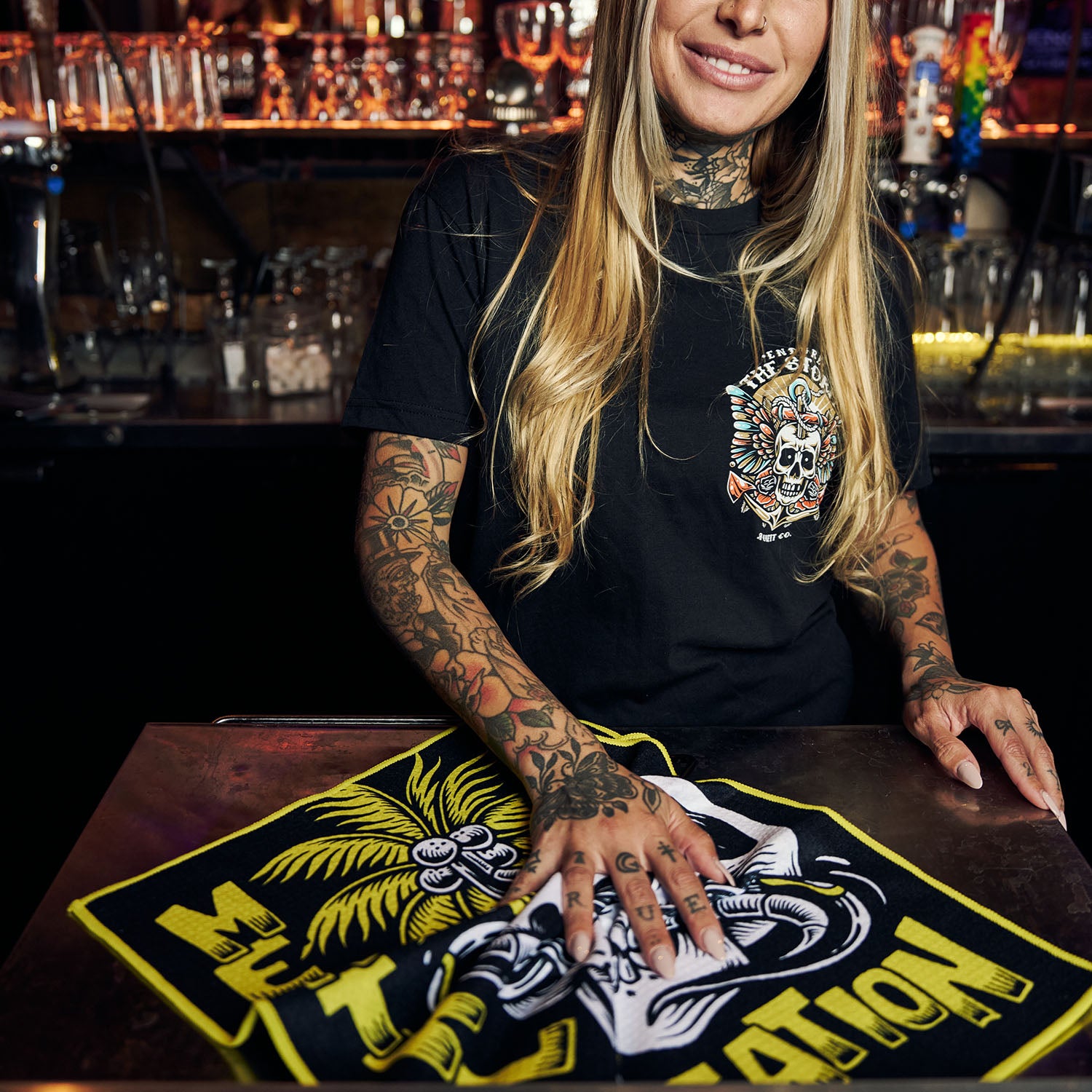 Female model using Utility Towel on bar top with 'Mental Vacation' graphic