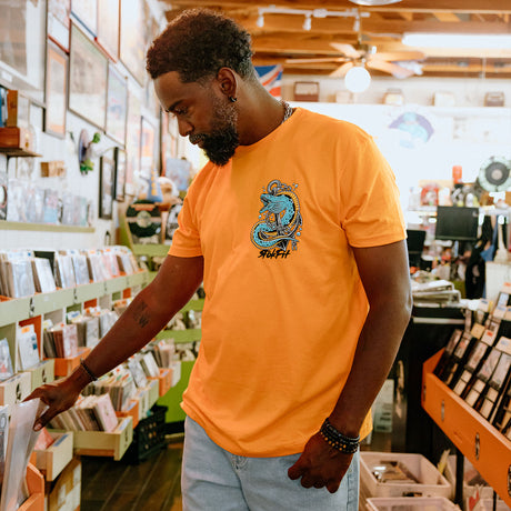 Male model in record store wearing unisex Active Tee with 'Prepare For The Unknown' graphic